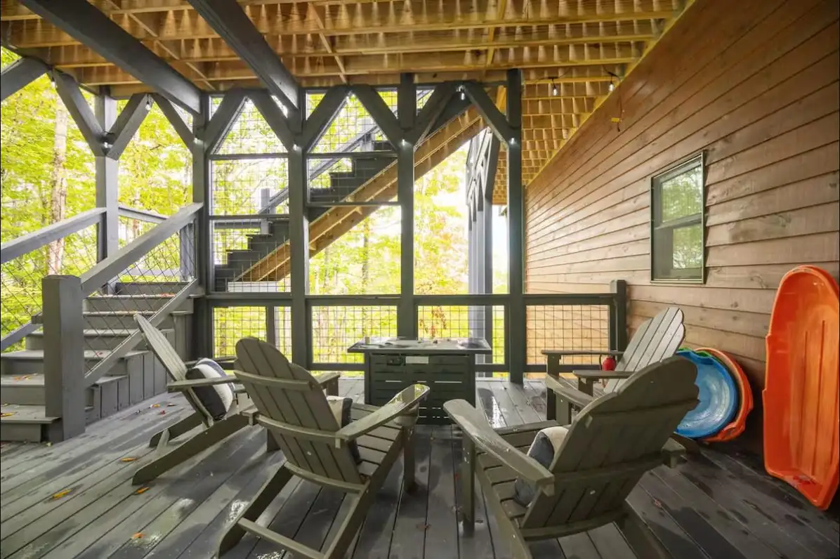 Under-deck lounge with fire table and Adirondack chairs built into the timber structure