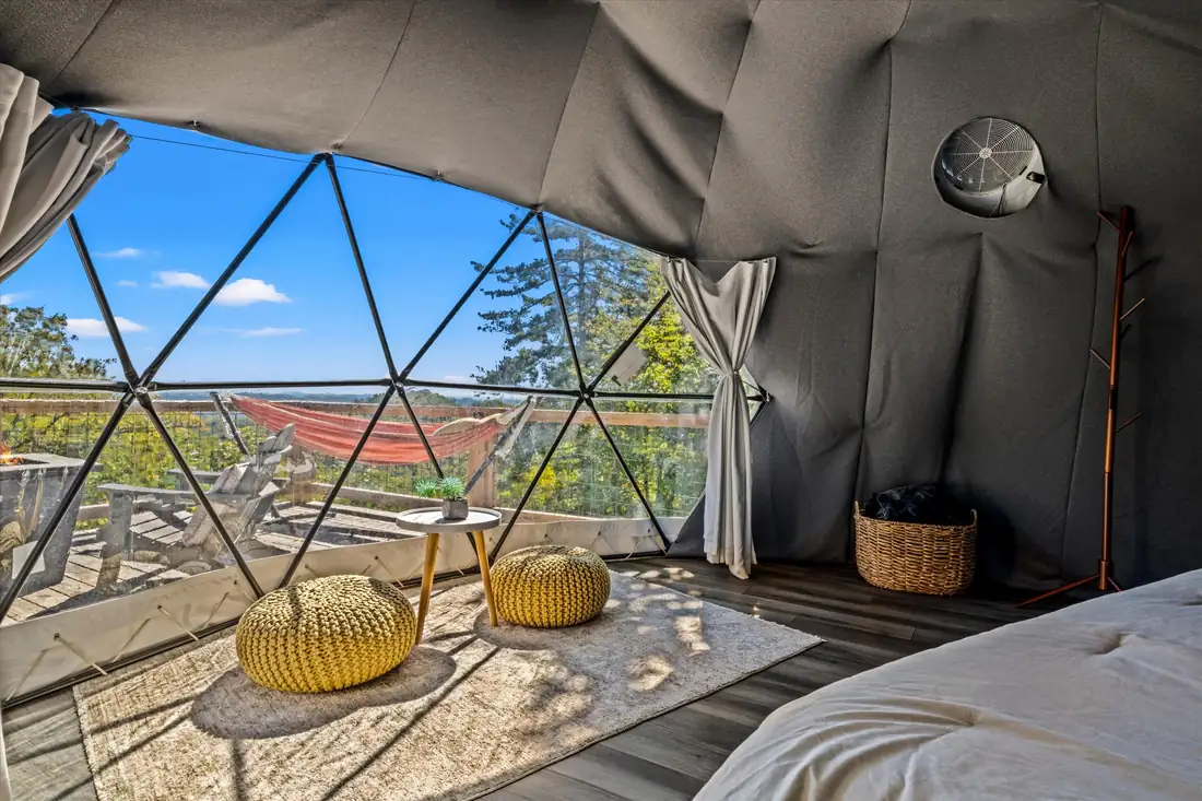 Inside a geodesic dome with panoramic window wall and mountain view