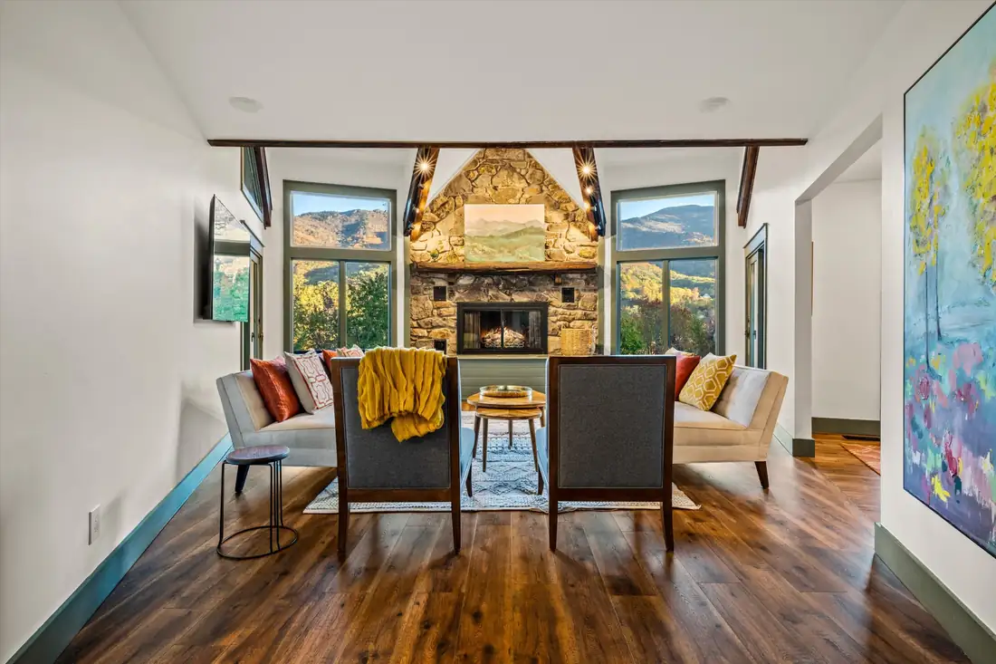 Designed mountain-home interior with stone fireplace and view windows