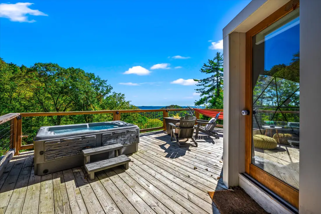 Hot tub set beside a stone patio with long mountain views