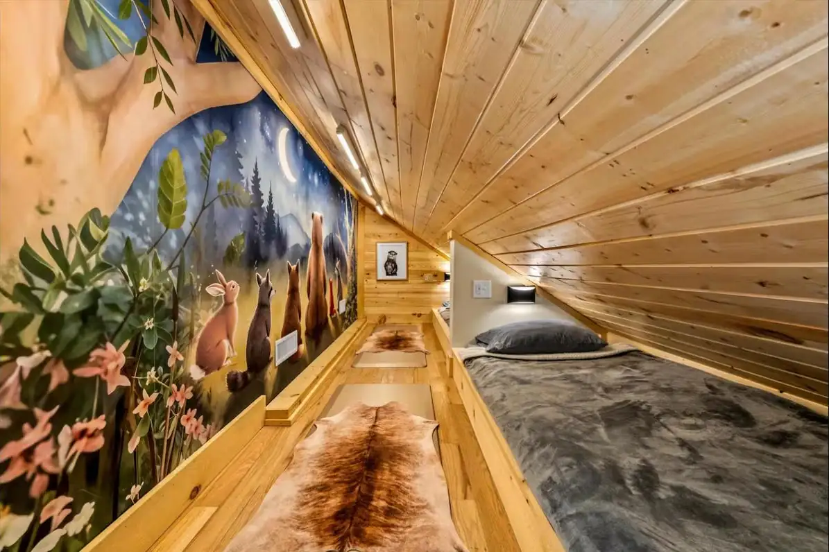 Attic kids bunk nook with a hand-painted woodland mural and reading beds