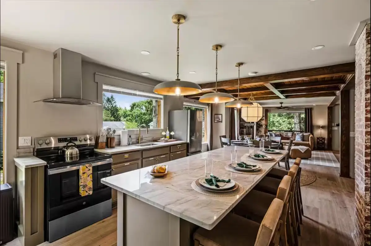Remodeled kitchen with marble island, custom cabinetry, and exposed beams