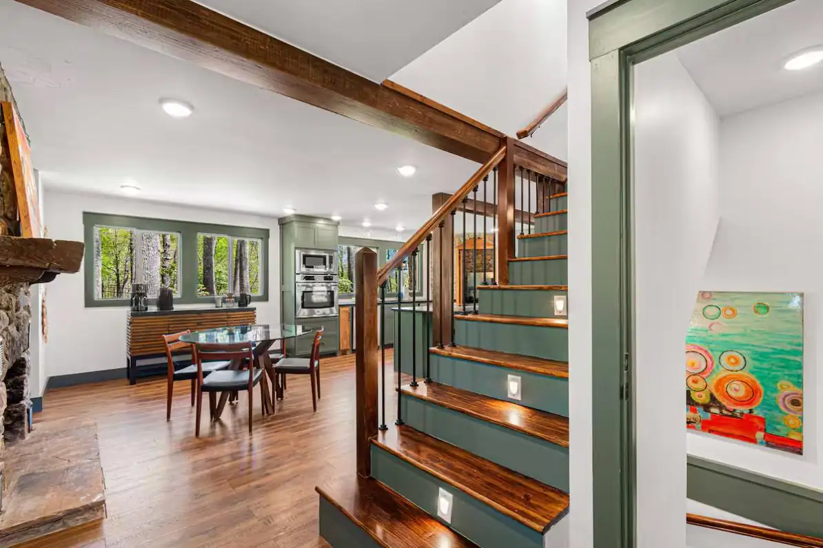 Custom staircase with wood treads and painted risers under an exposed timber beam
