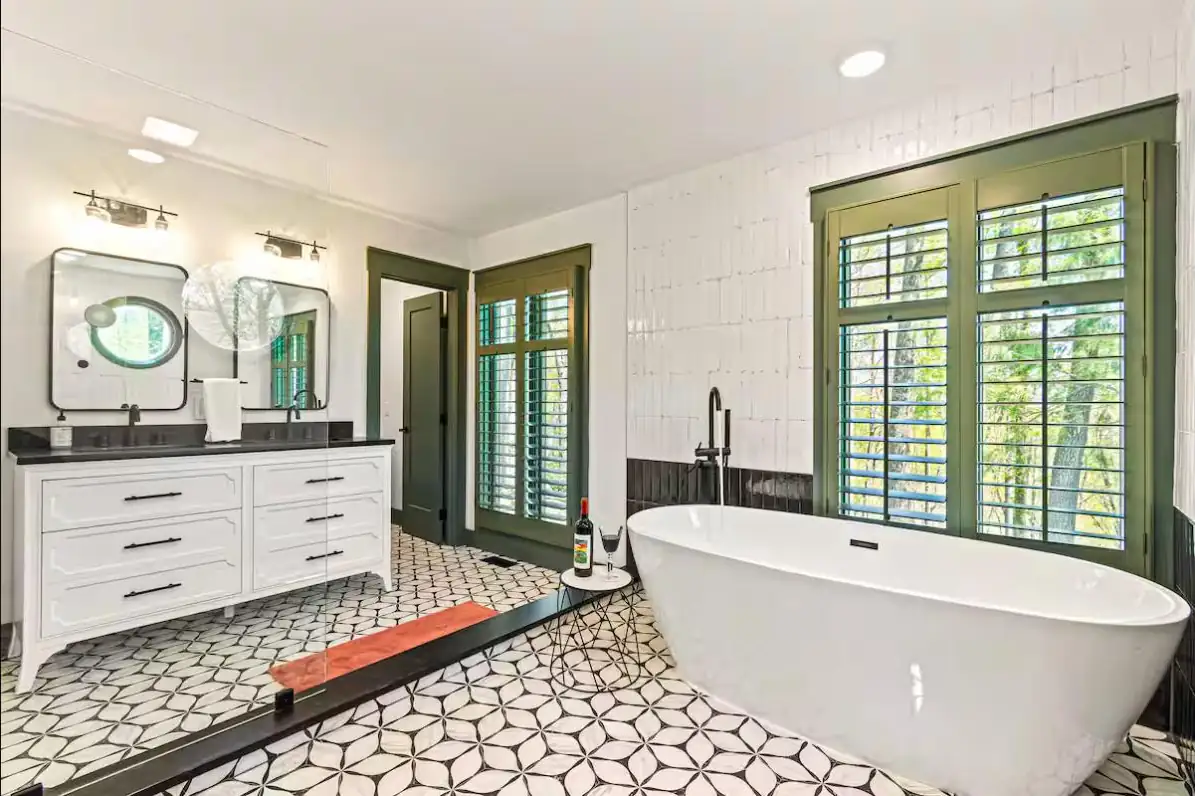 Master bath with patterned tile floor, freestanding tub, and double vanity